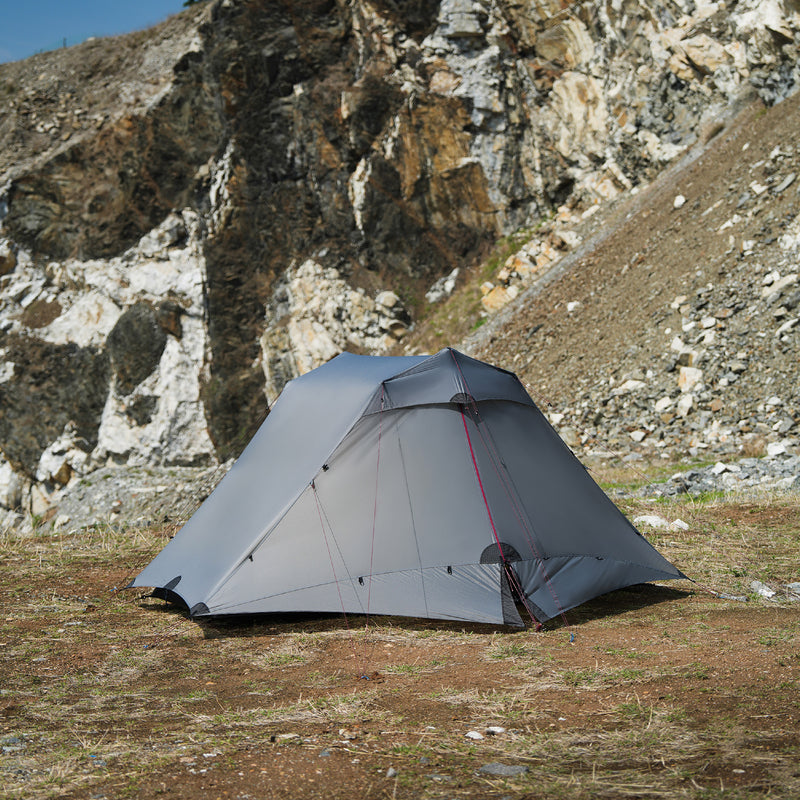 The Free Spirits Vista Tent in Rock Gray on rocky high-altitude ground, with red guyline cords.