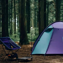 TFS Stars 4 camp in Royal Purple with a camping chair and lit lantern in the forest.