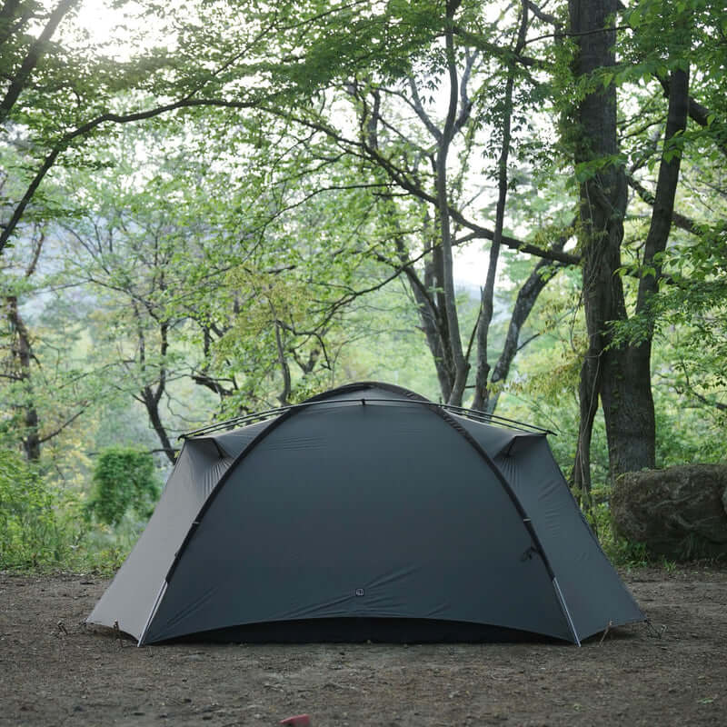 TFS Stars 4 tent in Holy Green pitched in a forest clearing, front view.