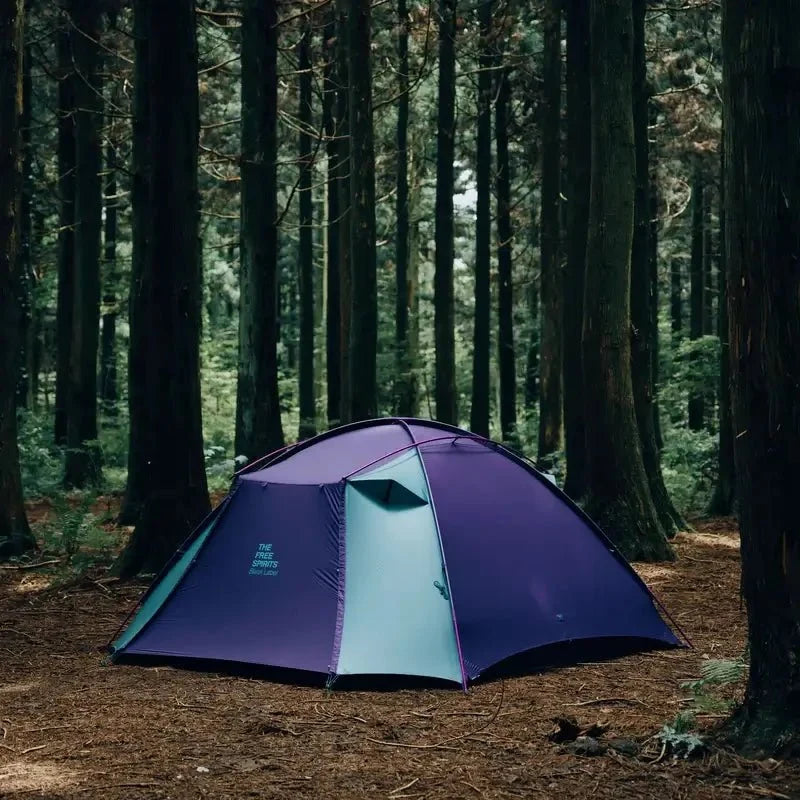 TFS Stars 4 tent in Royal Purple pitched under tall trees in a forest clearing.