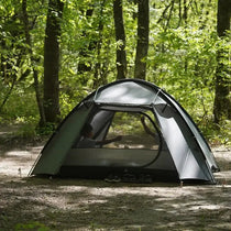 TFS Stars 4 tent in Holy Green in the woods, a camper visible through the mesh inner.